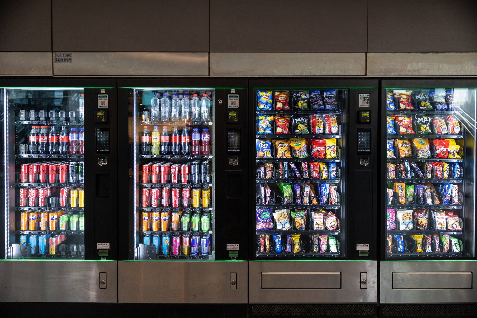 Vending machines filled with various bottled beverages and packaged snacks